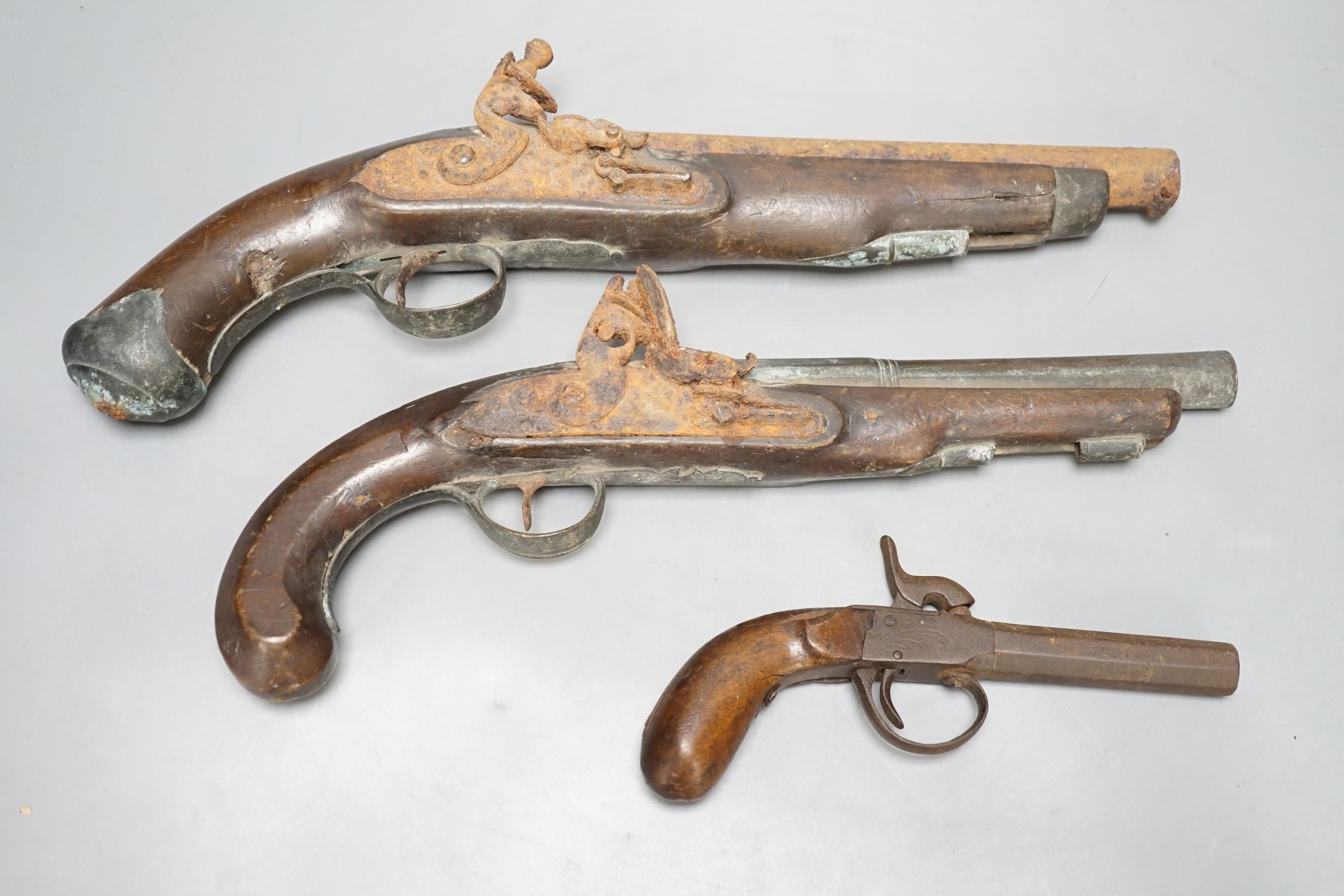 Two 19th century flintlock pistols and a pocket pistol, largest 40 cms long.